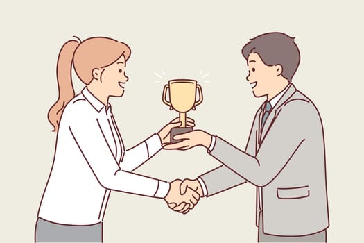Boss presents cup to subordinate in recognition of achievement and shakes hands to motivate
