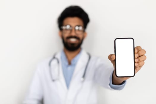 Smartphone with white screen in eastern doctor hand, mockup