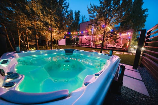 autonomous hot tub or jacuzzi with hot water and evening lighting