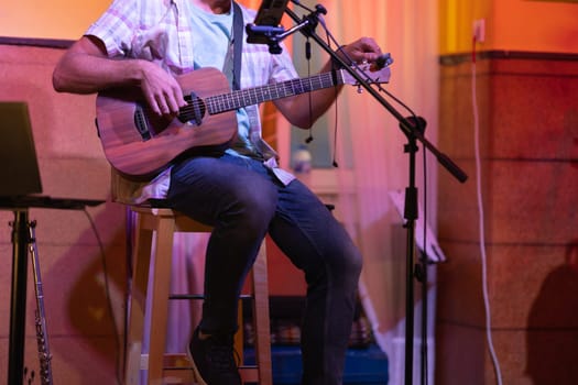 Man sitting on stage with an ukulele