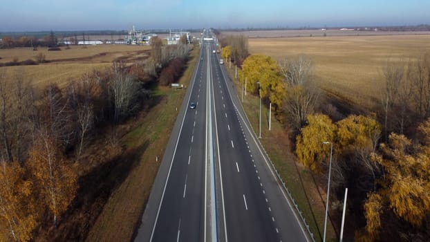 Cars driving along highway on autumn sunny day. Automobile road with markings