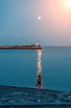 Woman The full moon rises to the lighthouse, the lunar path along the sea leads to the woman.