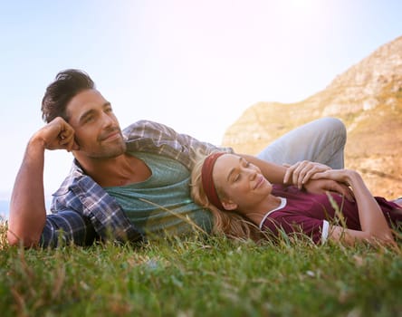 Relax, smile and love with couple in nature for mountains, bonding and affectionate. Happiness, date and romance with man and woman cuddle in grass field for summer break, happy and relationship