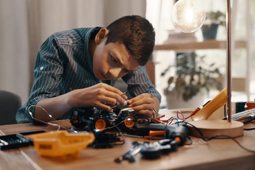 Education, car robot and kid in home with homework, homeschool and science, learning and tech project. Robotics, building and boy child with electrical knowledge, engineering and studying in house.