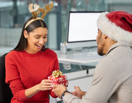 Christmas gift, office surprise and couple of friends at work with present and box. Holiday, event presents and giving a party package to a woman employee with love for celebration at workplace