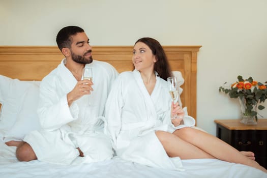 Couple In Love Tasting Sparkling Wine In Bedroom At Hotel