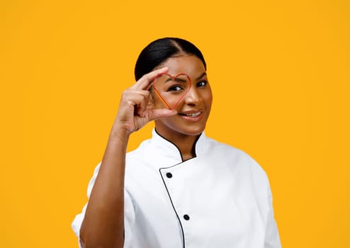 Smiling Black Chef Woman Looking Through Heart Shaped Cookie Cutter