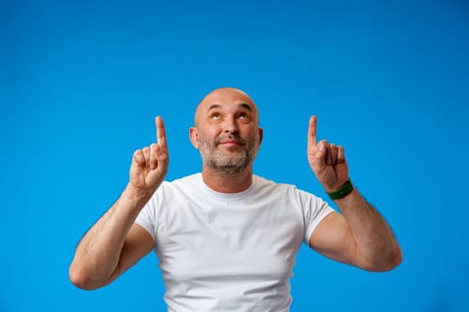 Handsome middle age mature man pointing to copy space