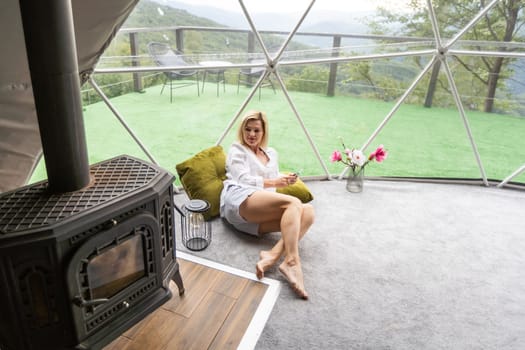 woman with smartphone in geo dome tent