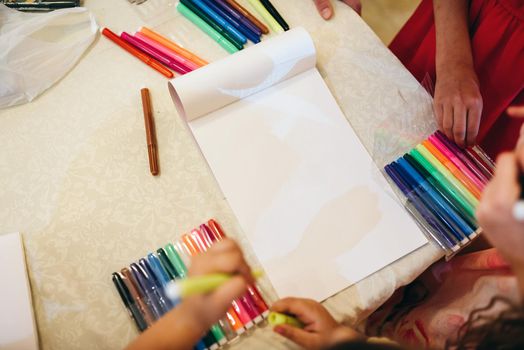 Children drawing with markers and having fun at home
