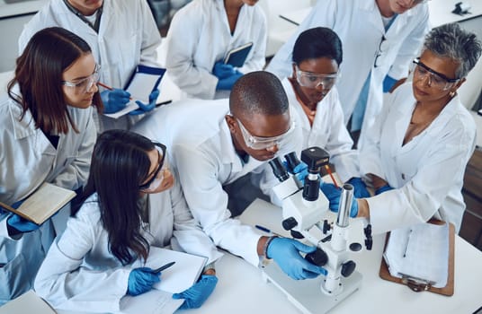 Student, microscope and science in university class, group and learning with woman lecturer, education or study. Students, scientist and medical research, dna lab or scholarship innovation at college