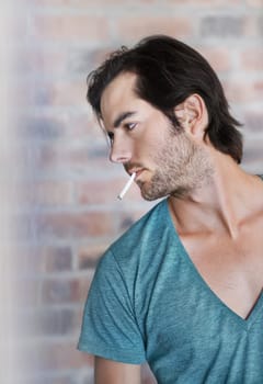 Smoking is part of his style. Close up profile of a handsome man with a cigarette in his mouth.
