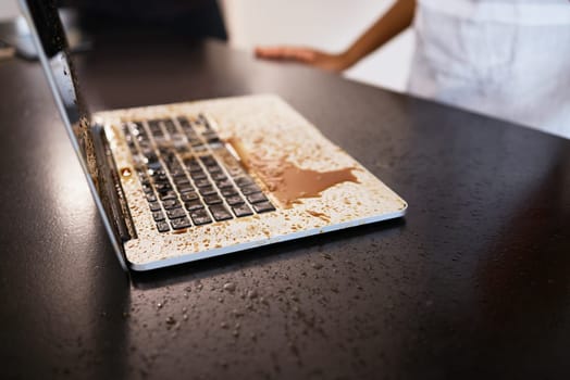 Remote work, accident and coffee splash on laptop in a kitchen, crisis and problem for woman working from home. Freelance, chaos and tea spill on a keyboard by female freelancer with computer damage