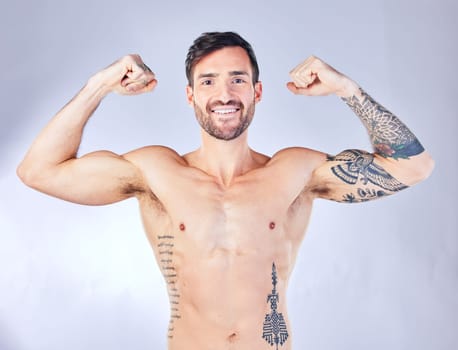 Bodybuilder, man and flex body, smile for wellness, after fitness and training with grey studio background. Muscles, arms and healthy man with motivation, workout and happy with progress and portrait