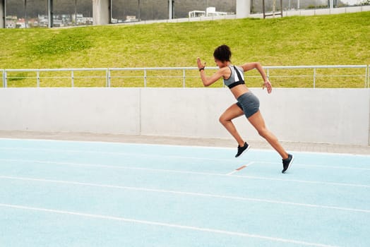 The finish line is my only limit. Full length shot of an attractive young athlete running a track field alone during a workout session outdoors.