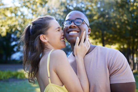 Summer, love and laugh with an interracial couple bonding outdoor together in a park or garden. Nature, diversity and romance with a man and woman hugging while on a date outside in the countryside.