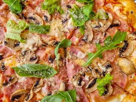 Traditional italian pizza with prosciutto, arugula and mozzarella cheese . Delicious italy flatbread with thin slices of ham cutout, mushrooms, arugula.hot tasty fast food top view