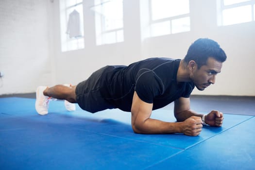 Sports, plank and fitness with man in gym for strong, workout and muscle. Exercise, power and health with male athlete and training on floor for wellness, abdominal challenge and balance