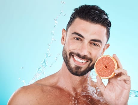 Skincare, water splash and portrait of man with grapefruit on blue background for vitamin c detox for healthy skin and smile. Fruit, water and facial wellness, spacleaning and happy male model face