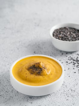 Creamy Cheddar sauce with chia seeds on gray background.Ideas and recipe for healthy diet or vegan food.Homemade Chia Cheeze Sauce for snacks,tacos,nachos,dipping,mac-n-cheese,base for pizza.Copyspace