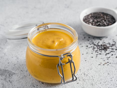 Creamy Cheddar sauce with chia seeds on gray background.Ideas and recipe for healthy diet or vegan food.Homemade Chia Cheeze Sauce for snacks,tacos,nachos,dipping,mac-n-cheese,base for pizza.Copyspace