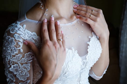 the bride holds in her hands a beautiful wedding dress