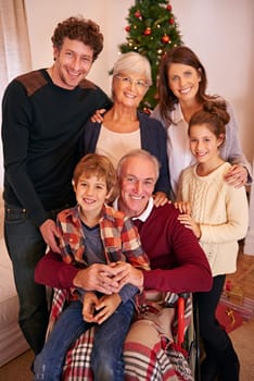 Christmas, happy and big family portrait in home with young children, parents and grandparents. Happiness, love and festive holiday celebration with kids, grandma and grandpa together in house.