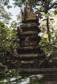 Close up shot of temple sculpture in sacred monkey forest on green nature background