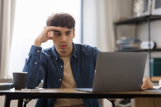 Bored Middle Eastern Guy Sitting At Laptop Hating Job Indoors