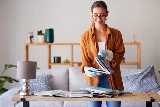 Cleaning, happy and woman with books in the living room, inspection and content with housework. Smile, check and cleaner spring cleaning a book for housekeeping and decluttering in lounge of a house