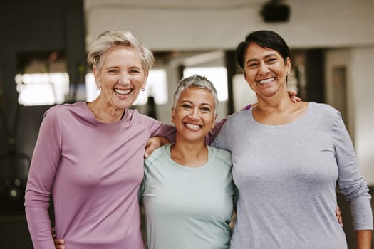 Elderly woman, exercise group and portrait with hug, smile and support for wellness goal. Senior women, team building and happiness at gym for friends, solidarity or diversity for teamwork motivation
