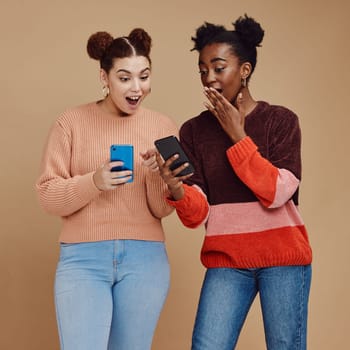 News, wow and shocked people isolated on studio background for social media, gossip or trendy online sale. Smartphone, surprise notification and gen z friends, black woman reading announcement mockup.