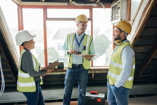 Teamwork, planning and engineers talking at construction site for repairs, maintenance or renovation. Tablet, clipboard and collaboration of contractors or architects in discussion at building site.