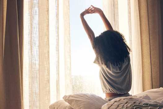 Black woman, back stretching and waking up in home bedroom after sleeping or resting. Relax, peace and comfort of female stretch after feeling fresh, awake and well rested to start morning in bed.