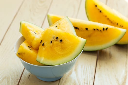 Yellow watermelon sliced on wooden background