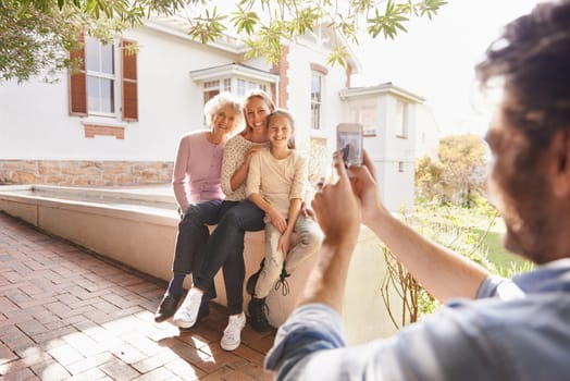 Picture, family and happy grandma, mother and child bonding, smile and father taking outdoor generations photo. Cellphone, support and happiness of young kid, mom and elderly grandma in home backyard