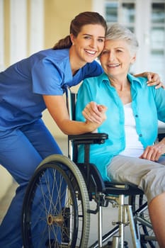 Portrait, caregiver or happy elderly woman in a wheelchair in hospital helping a mature patient for support. Smile, disabled or healthcare social worker smiling with a senior person with a disability