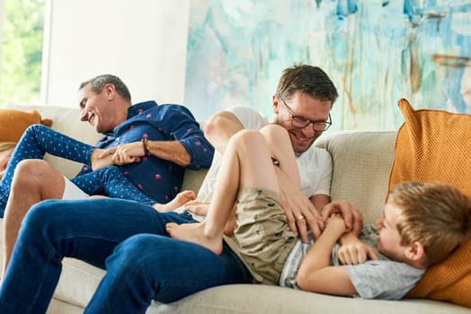Gay parents, family and tickling in living room with dads and kids together with laugh. Parent love, bonding and care with father, papa and children in a home with a smile or fun lgbt people in house