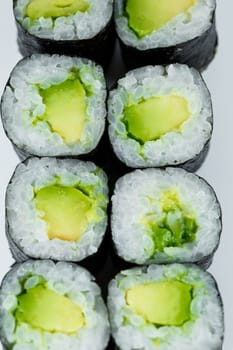 Japanese food. Rolls with ripe avocado, fresh rice with vegetables in nori. Vegetarian rolls
