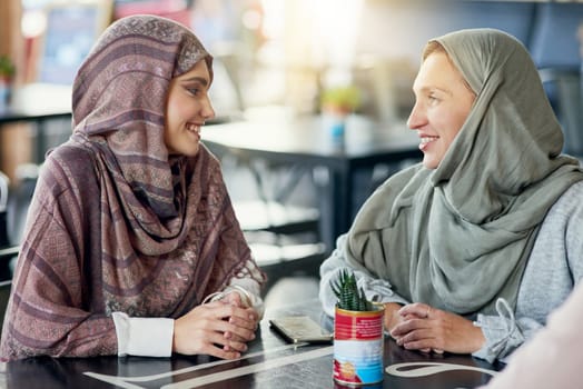 Friends, happy and Muslim women in cafe, bonding and talking together. Coffee shop, relax and Islamic girls, group or people chat, conversation and discussion for social gathering in restaurant.