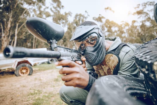 Paintball, man and gaming, gun and target with sport, fitness on battlefield and challenge with war soldier outdoor. Extreme sports, aim weapon and shooting range with military mission and training