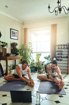 The best yoga channel by far. two men using a laptop while going through a yoga routine at home