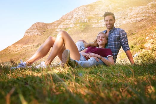 Relax, love and portrait of couple in nature for carefree, bonding and affectionate. Happiness, date and romance with man and woman cuddle in grass field for summer break, happy and mountains