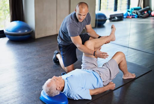 Rehabilitation can be tough going. Cropped shot of a handsome personal trainer with a senior man.