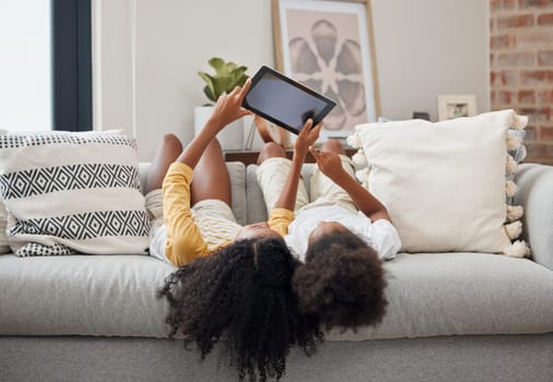 Relax, sisters and girl with a tablet, home and connection for social media, communication and chatting. Female children on a couch, young people and kids with technology, typing and watching videos.