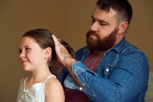 Hairdo by Dad. a father brushing his daughters hair at home.