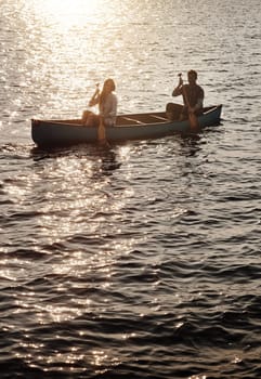 Take to the lake and enjoy adventures. a young couple rowing a boat out on the lake.