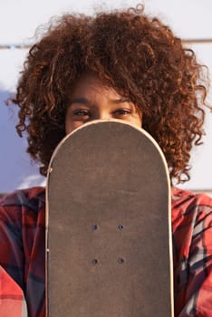 Hide, face and portrait of woman with skateboard for fitness, urban and hiding in outdoors. Training, skating and youth with african female skater and cover for hipster, relax and skateboarder afro