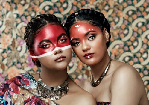 The worlds beauty lies in its various cultures and diversity. Portrait of two attractive young women dressed in traditional attire and makeup posing together against a patterned background.