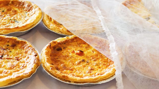 Bakery, quiche and bread pastry in a store with coffee shop food and product in a kitchen. Savory pie, closeup and diner with cloth and vegetable dessert in a cafe with flour and crust for a snack